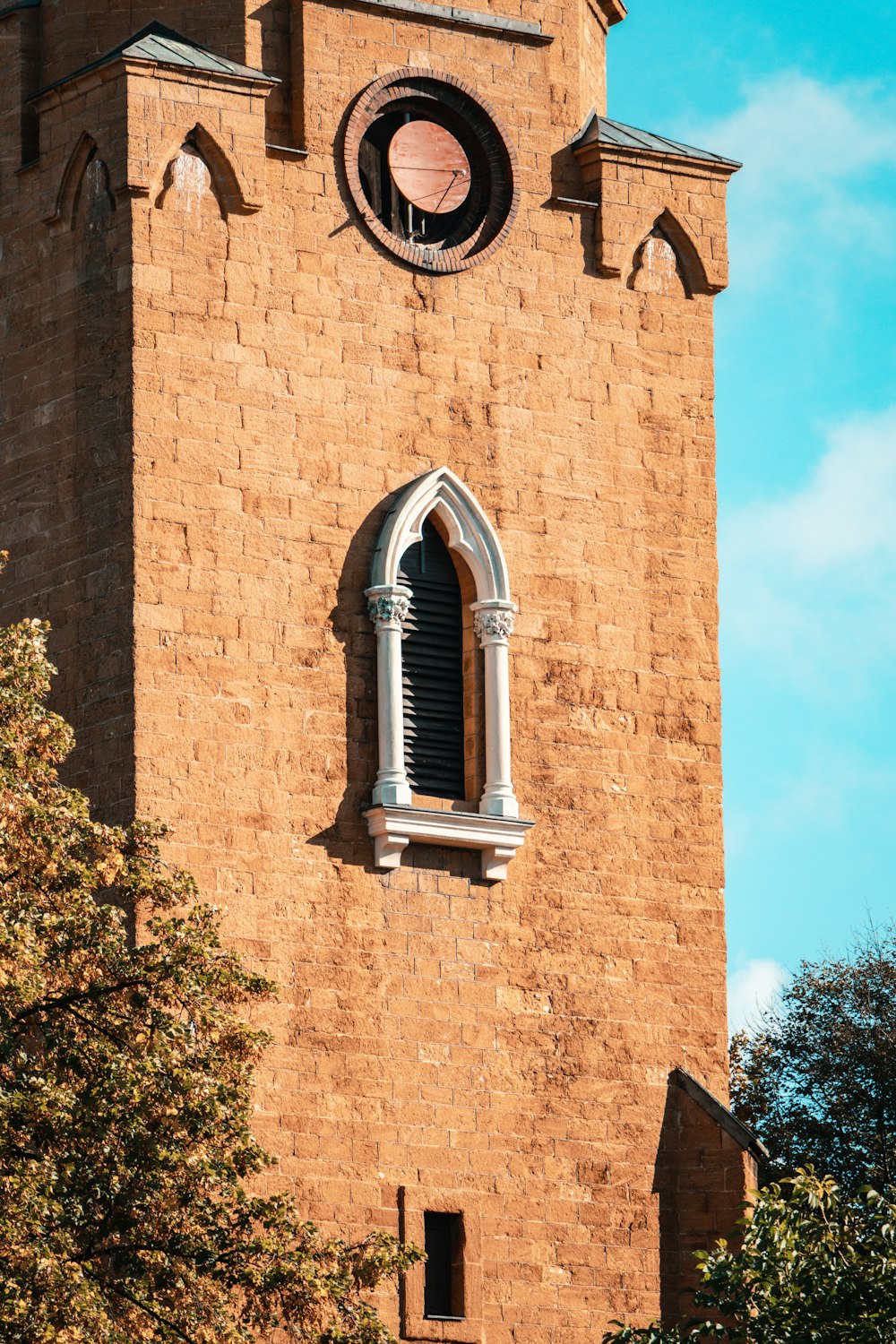 a tall brick tower with a clock on it's side