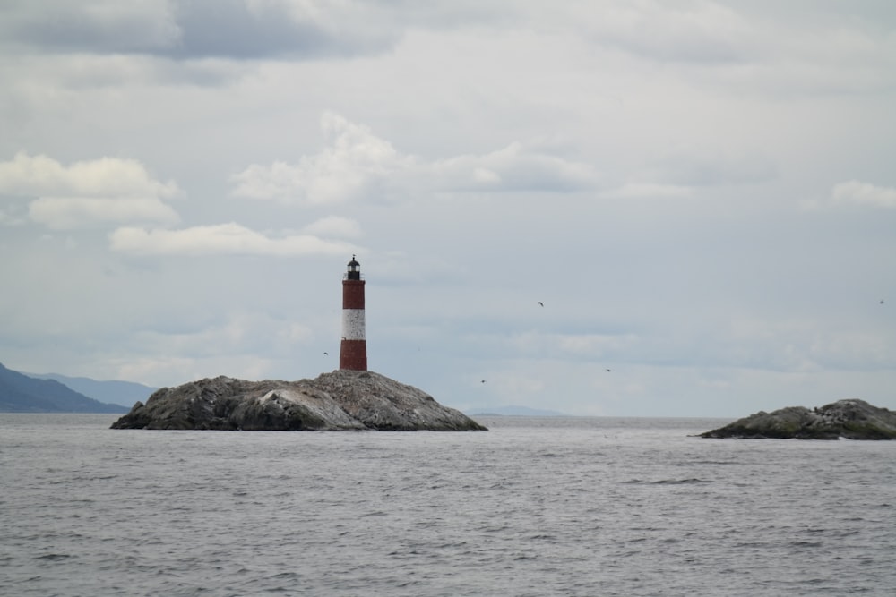 a light house on a small island in the middle of the ocean