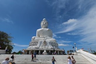 a large white buddha statue sitting on top of a set of steps