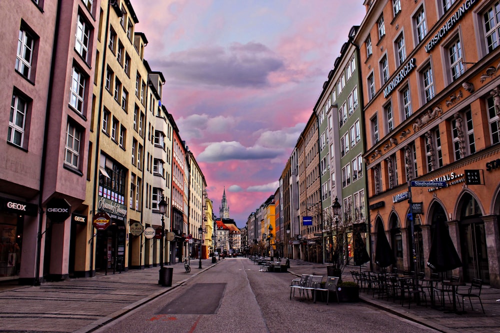 a street lined with tall buildings under a cloudy sky