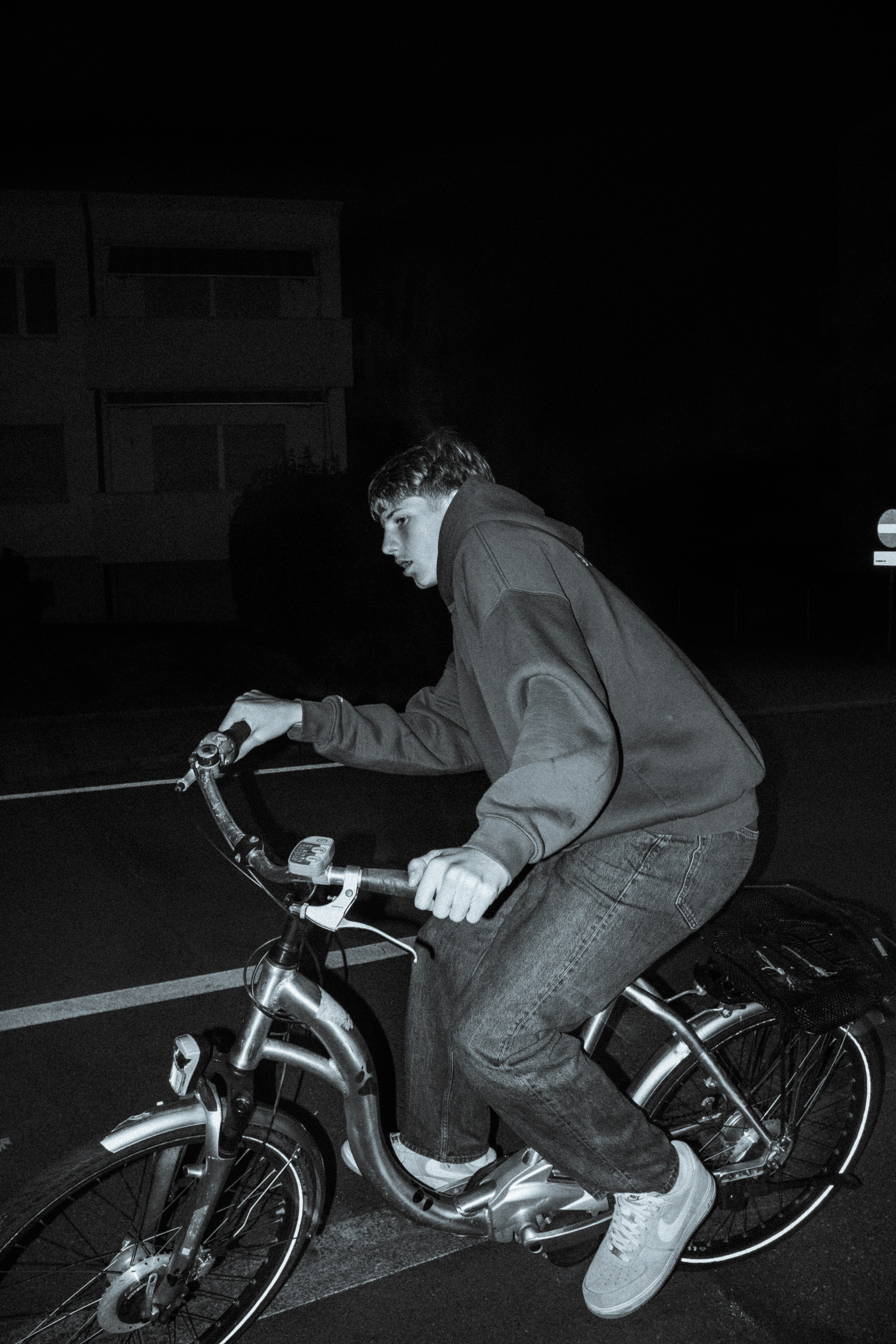 Un uomo che guida una bicicletta lungo una strada di notte