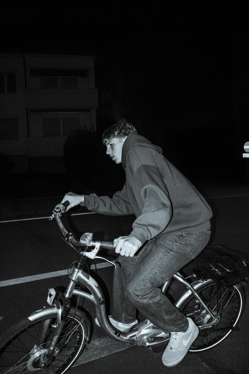 a man riding a bike down a street at night