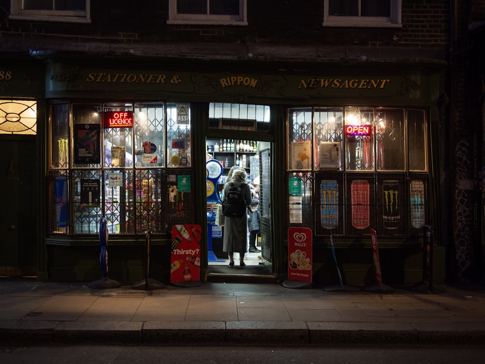 a man standing in the doorway of a store at night