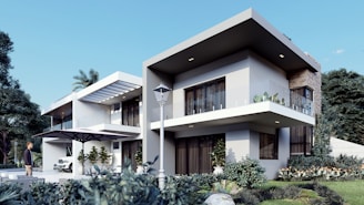 A modern two-story house with large windows and a flat roof design, surrounded by lush greenery. The exterior features a combination of white and stone facades, with a glass balcony on the upper floor. A vintage car is parked in the driveway, and a person is standing nearby. The outdoor space includes a large umbrella and manicured plants, with a tall, slender lamp post adding a touch of elegance.
