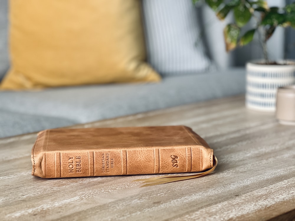 Un libro marrón sentado encima de una mesa de madera