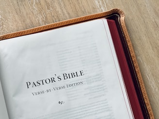a bible opened on a table with a pen