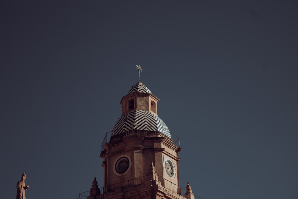 un'alta torre dell'orologio con una croce in cima