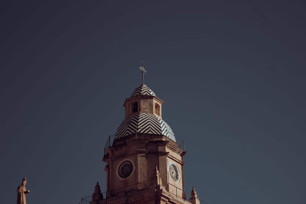 a tall clock tower with a cross on top