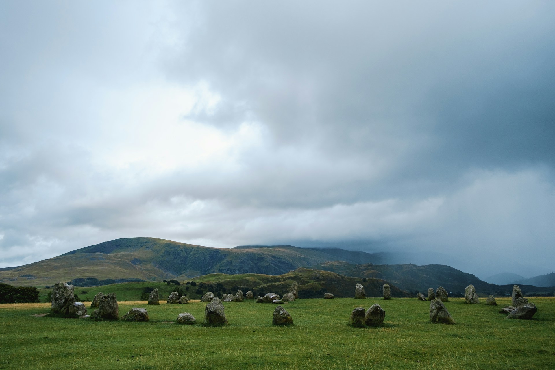 a grassy field with large rocks in the middle of it