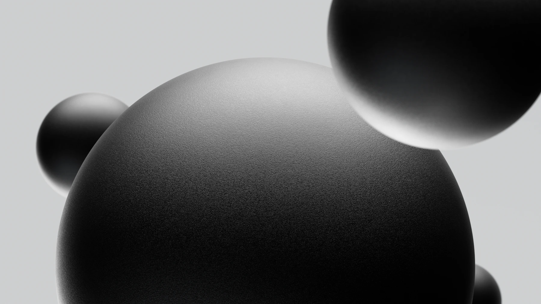 Soft grey spheres resting on a pale surface