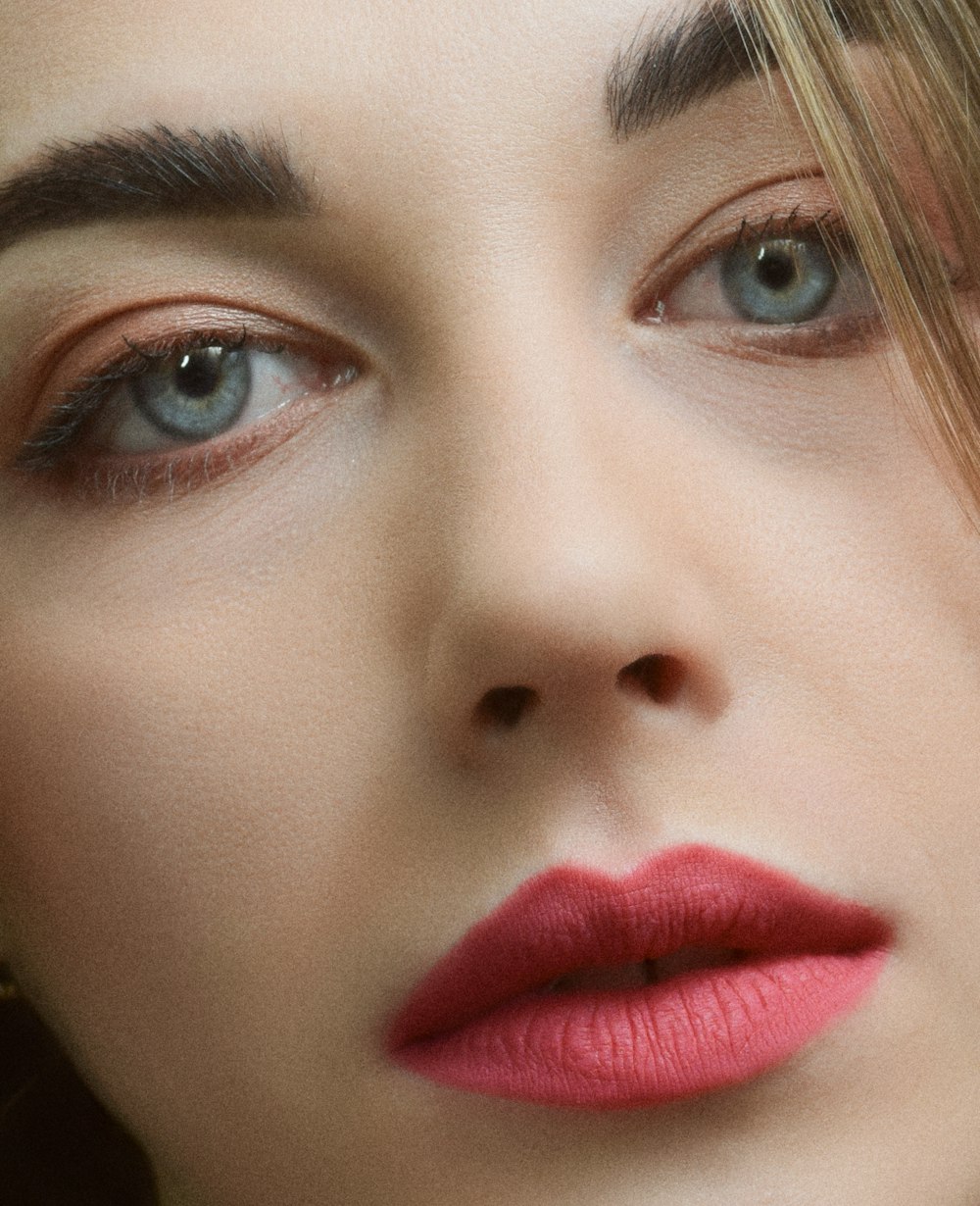 a close up of a woman with red lipstick