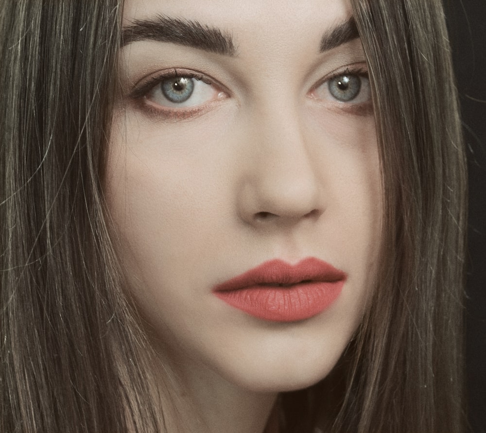 a woman with long hair and red lipstick