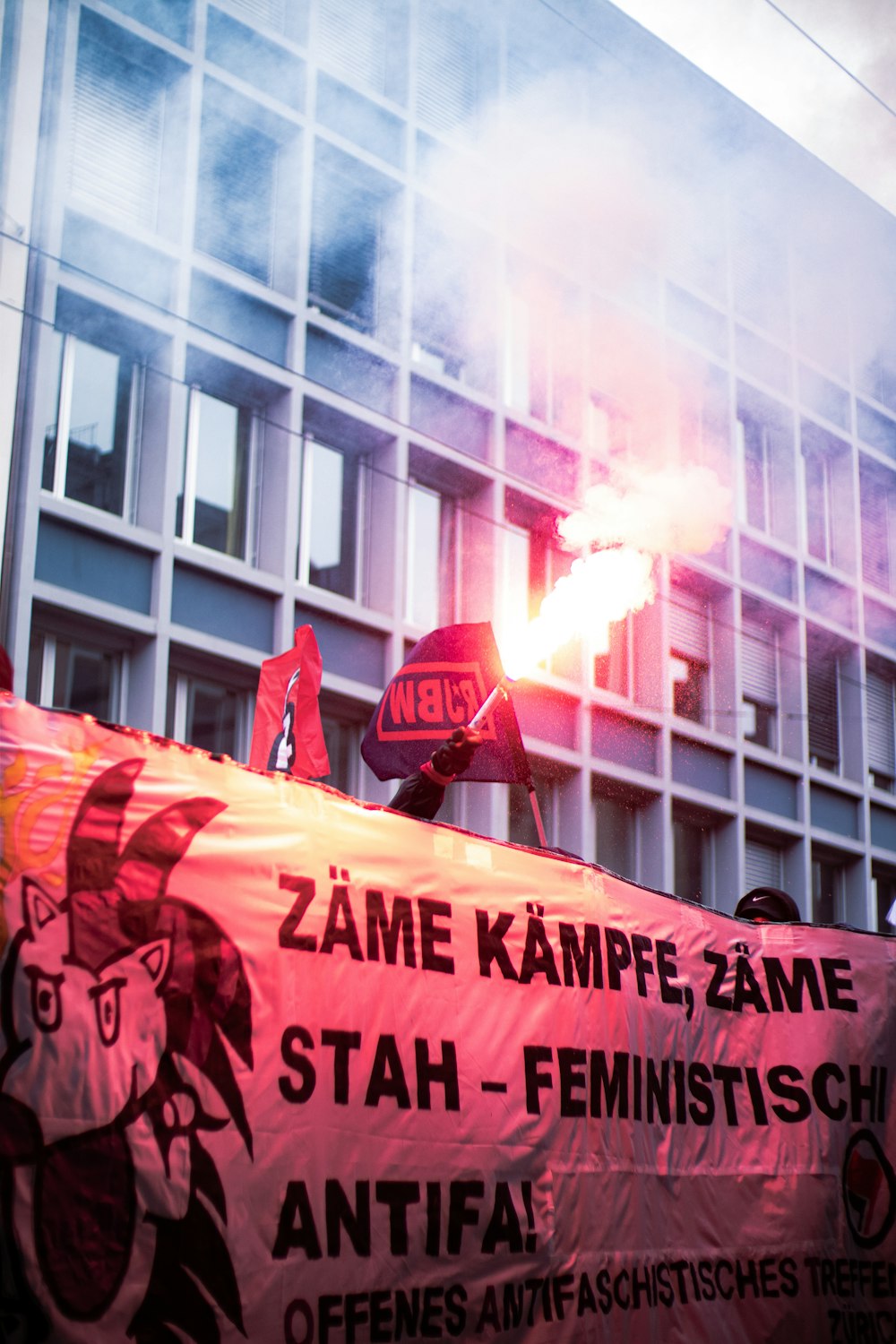 a group of protesters holding a large red banner