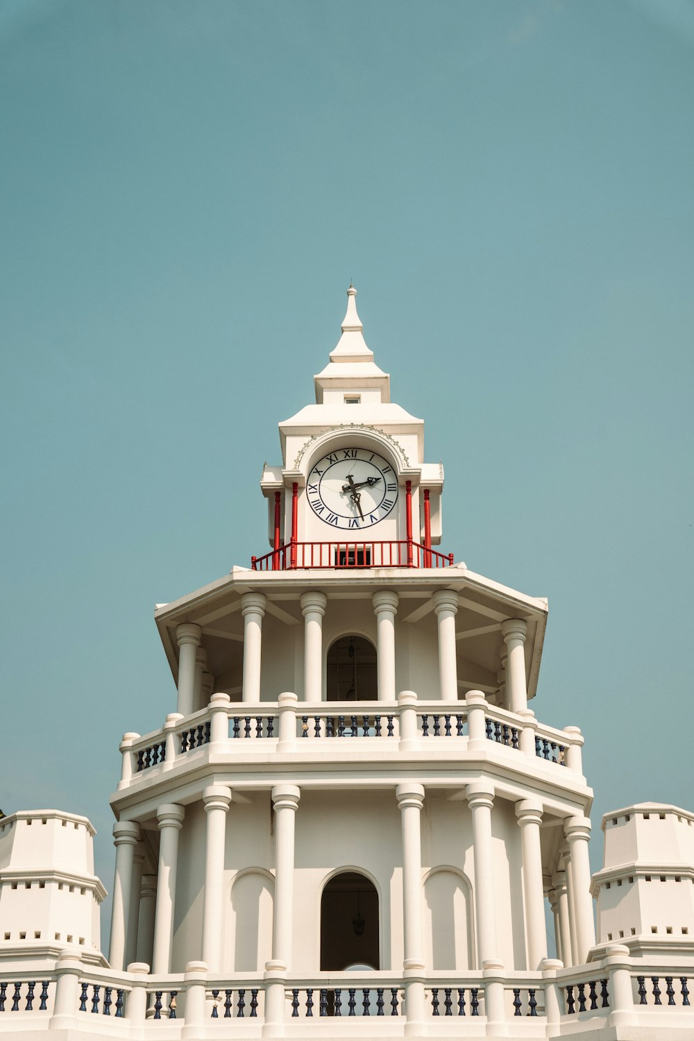 a large white clock tower with a clock on each of it's sides