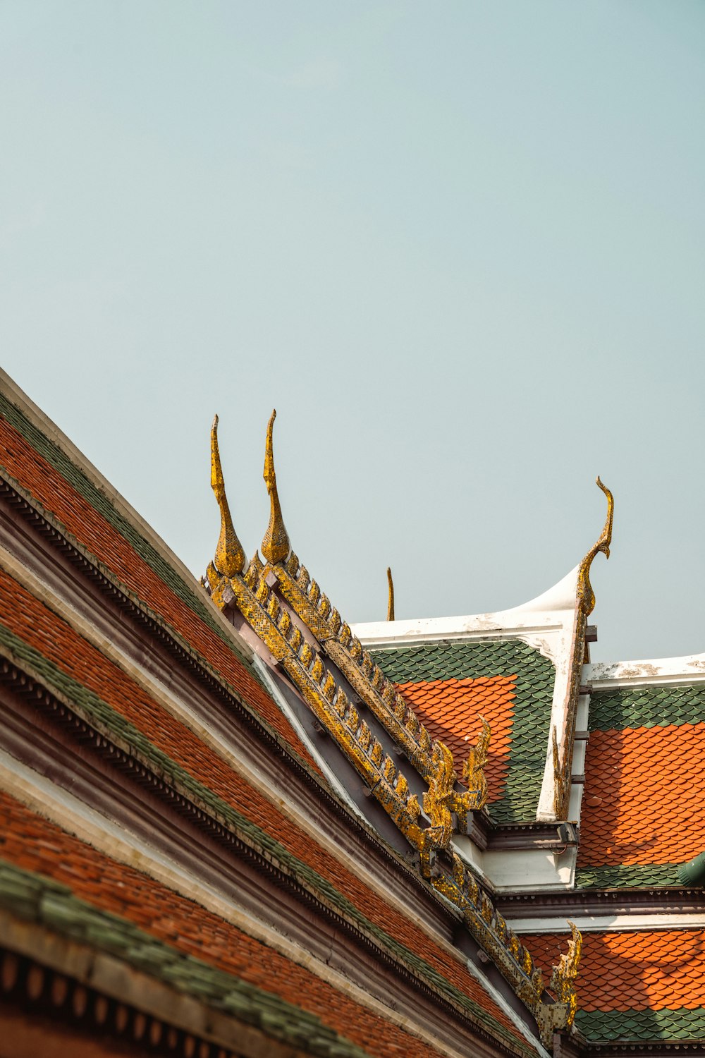 o telhado de um edifício com gárgulas douradas sobre ele