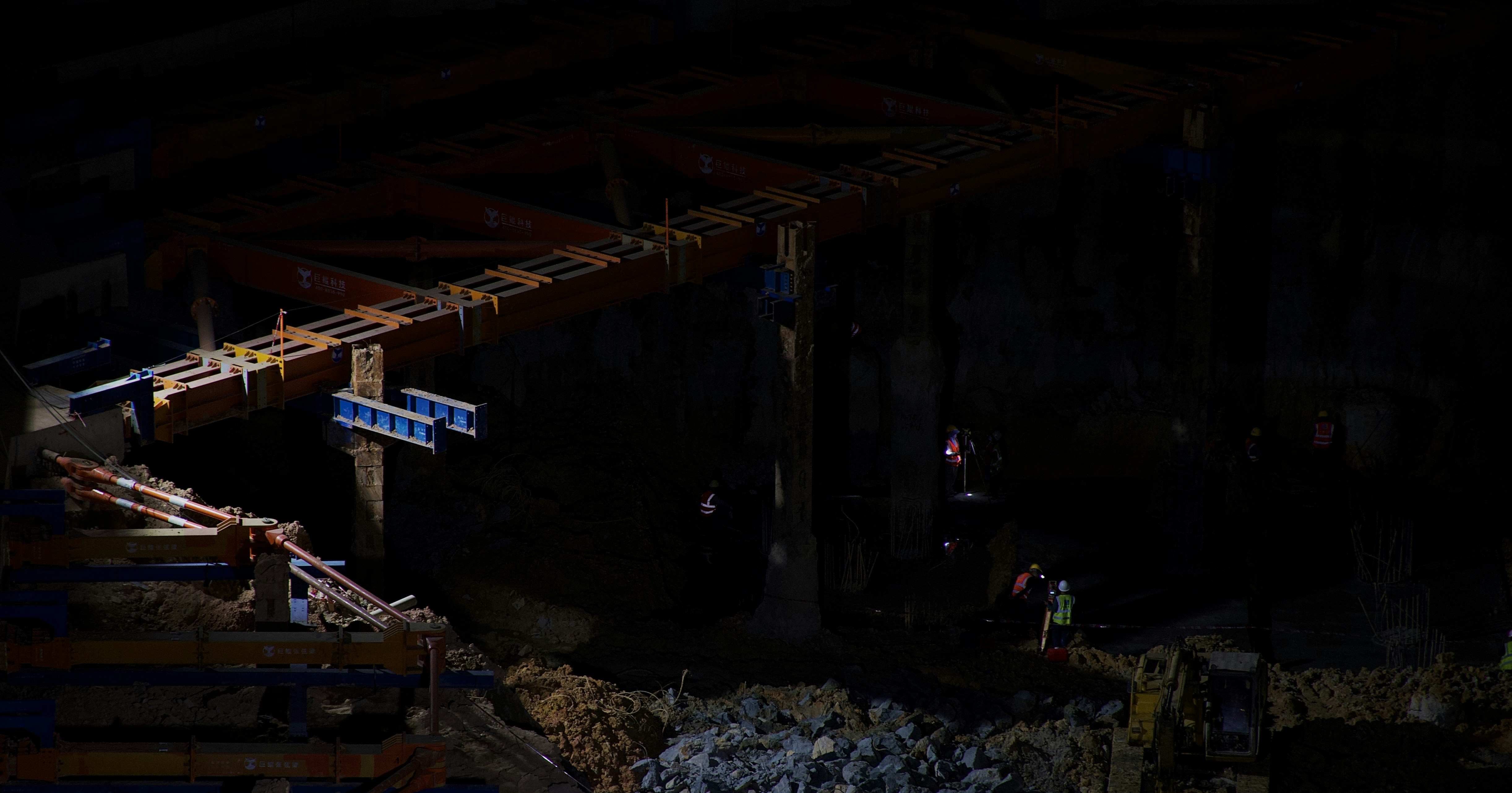 un sitio de construcción por la noche con trabajadores trabajando en él
