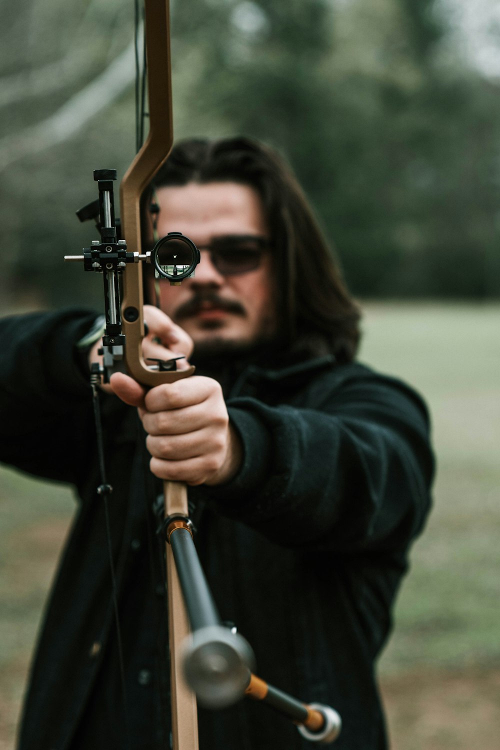 a man with long hair holding a bow and arrow