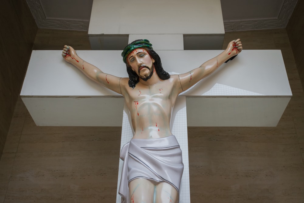 uma estátua de Jesus na cruz com sangue por toda parte
