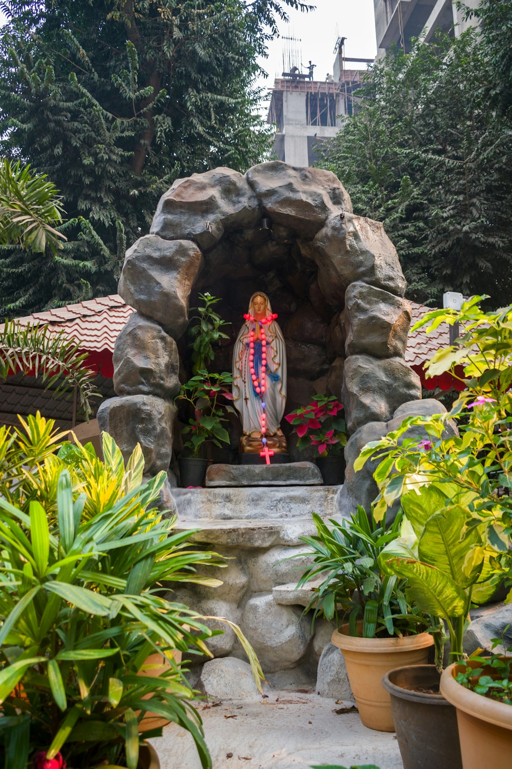 uma estátua de uma pessoa em pé em um jardim