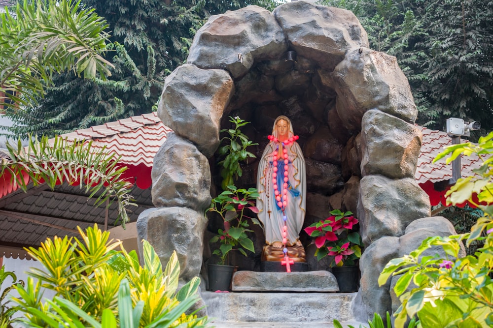 uma estátua da virgem maria em um jardim