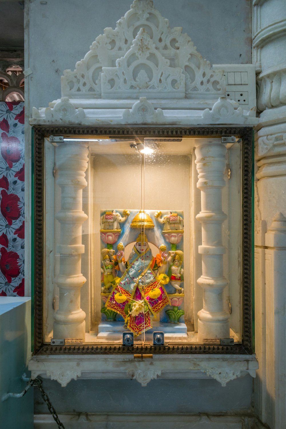 a small shrine with a painting on the wall