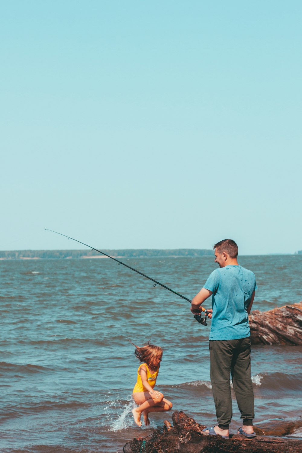 a man and a child fishing in the ocean