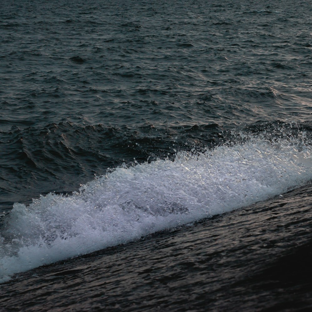 a man riding a surfboard on top of a wave in the ocean