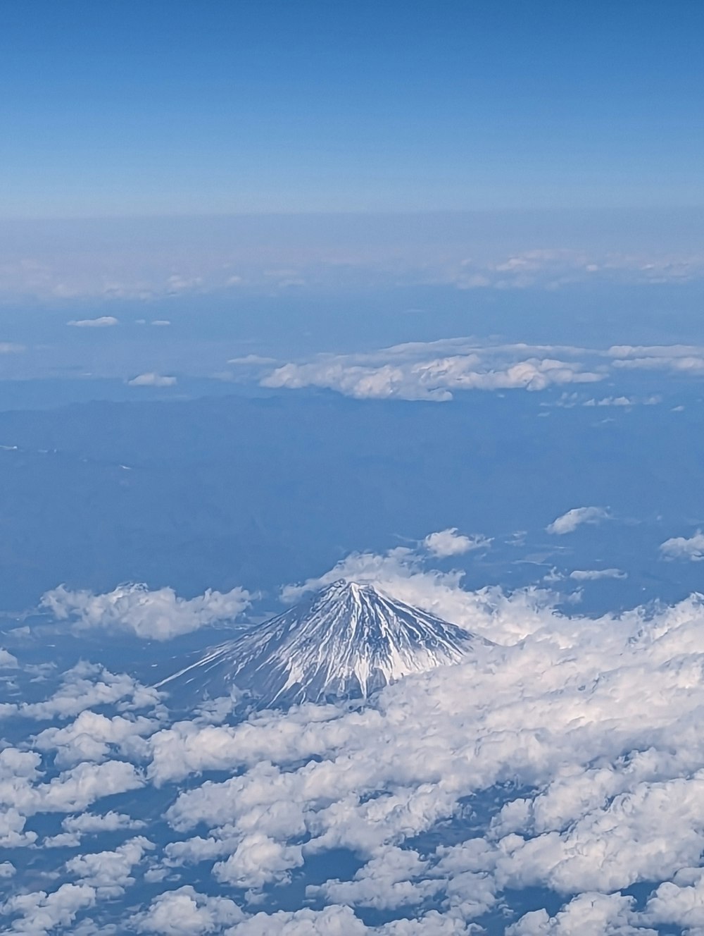 a view of a snow capped mountain from an airplane