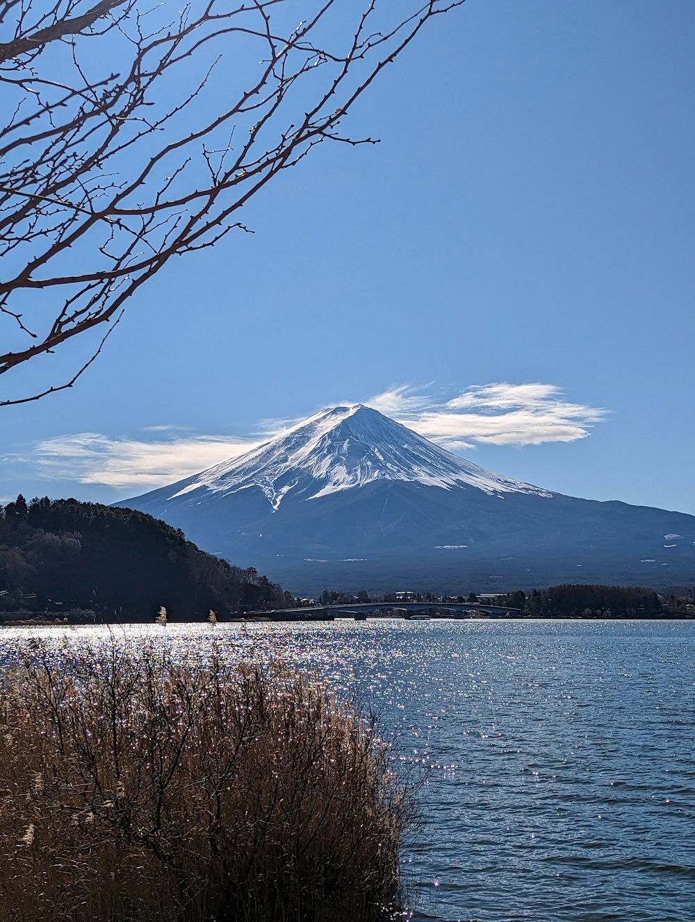 una montaña con nieve y un cuerpo de agua frente a ella