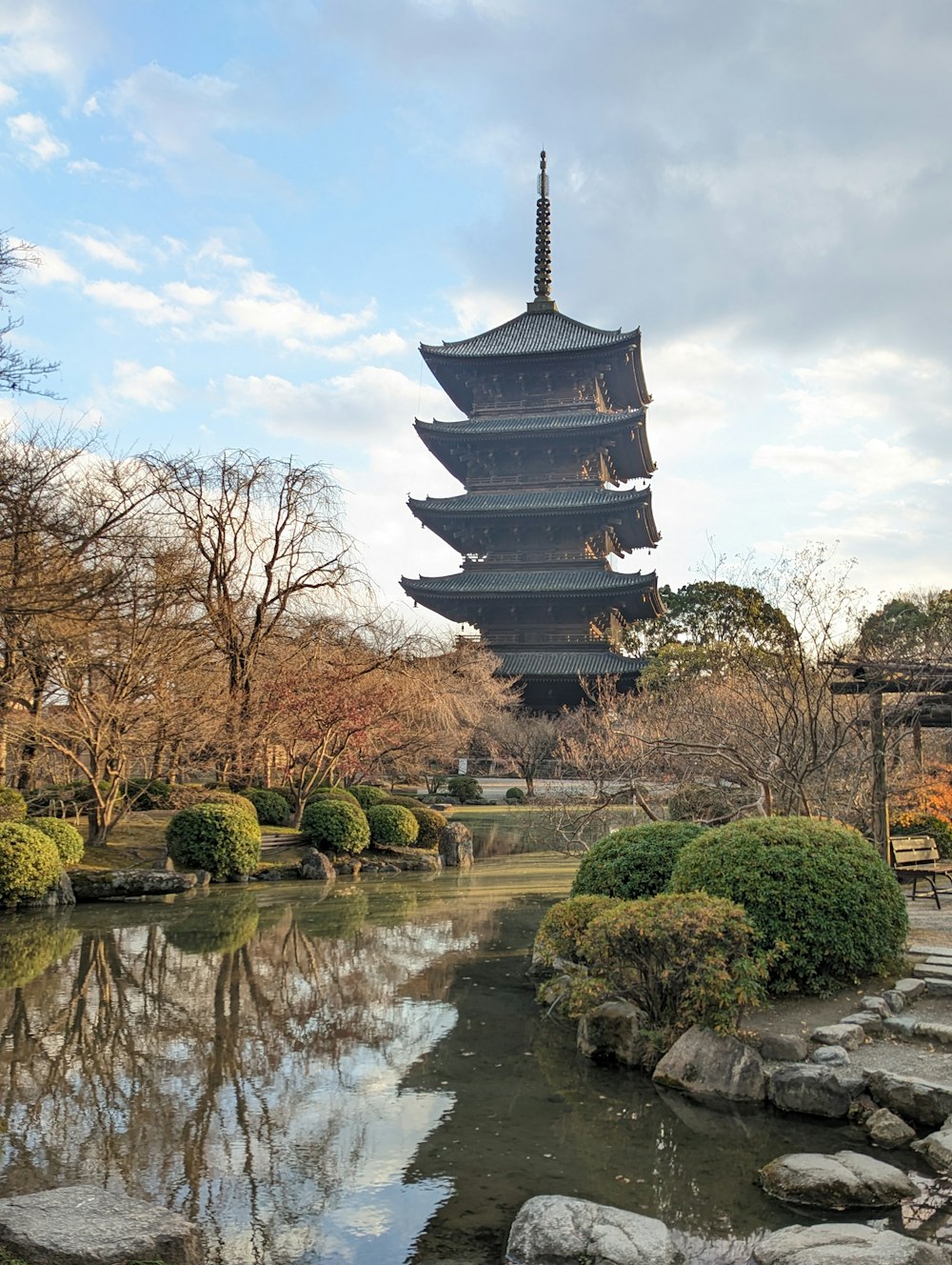 a pagoda is reflected in the water of a pond