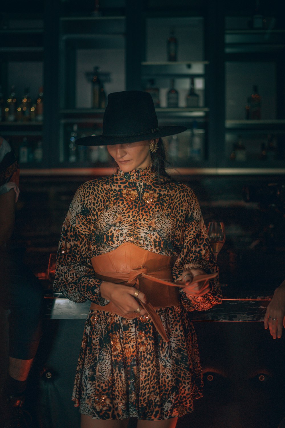 a woman in a leopard print dress and a cowboy hat