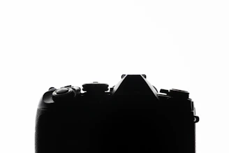 A striking black background with a white minimalist camera icon symbolizing photography services.