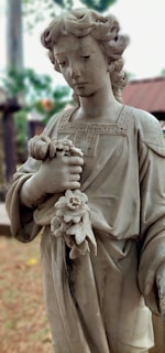 A serene portrait of a child holding a flower in a sunlit garden