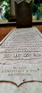 Close-up of restored golden lettering on a weathered tombstone.