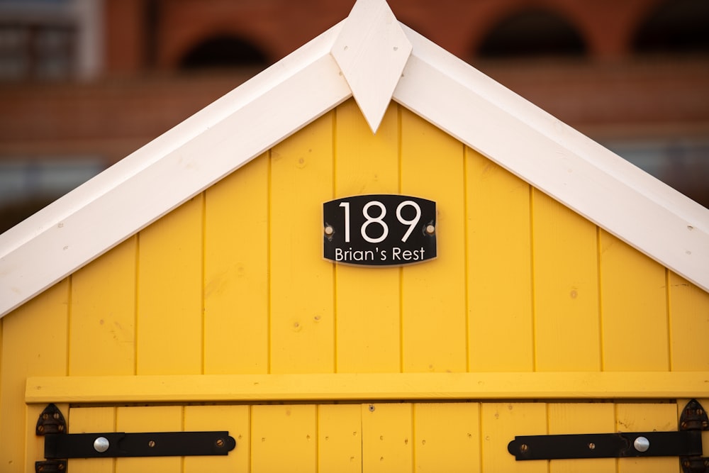 a yellow building with a white roof and a sign on it