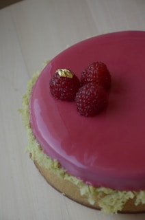 Close-up of a pink velvet cake adorned with delicate gold leaf accents.
