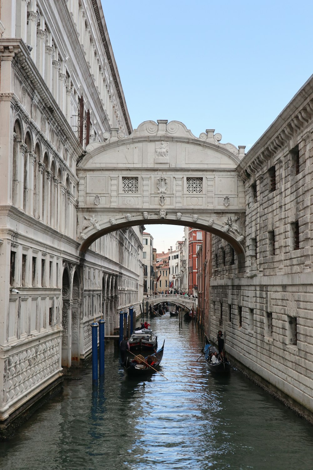 a bridge over a canal with a few boats in it