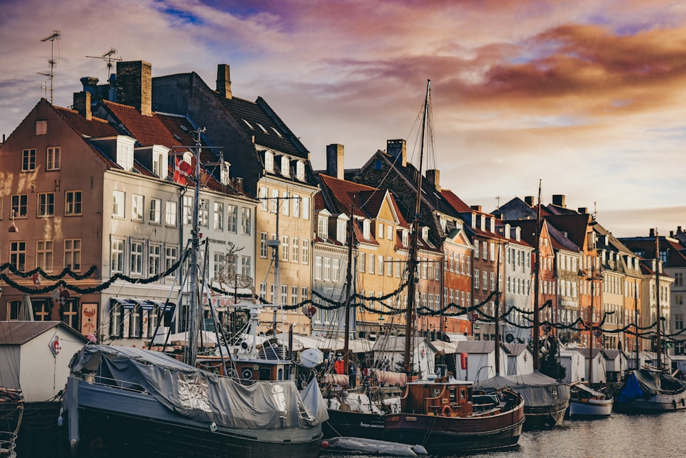 a group of boats parked next to a row of buildings