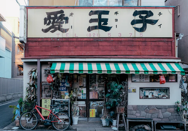 A clean, minimalist Japanese-inspired storefront with sakura blossoms subtly decorating the entrance.