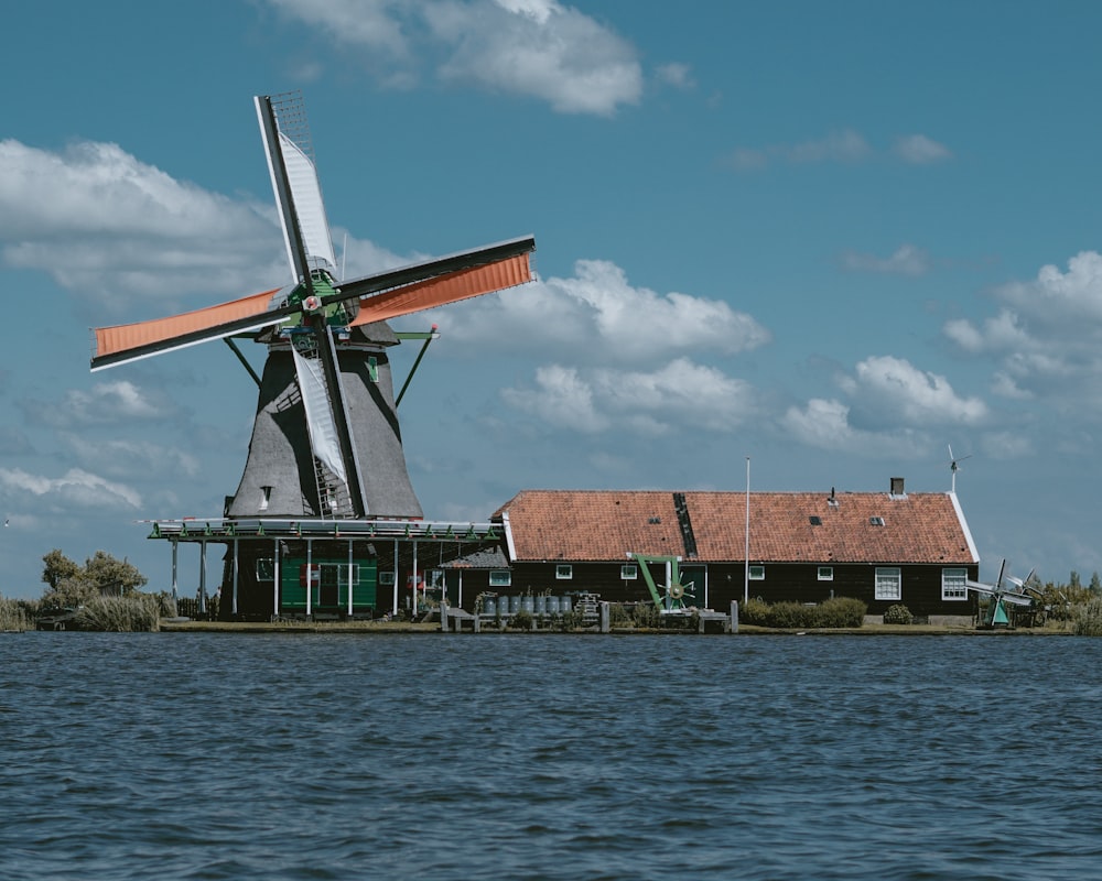 Un molino de viento sentado encima de un cuerpo de agua