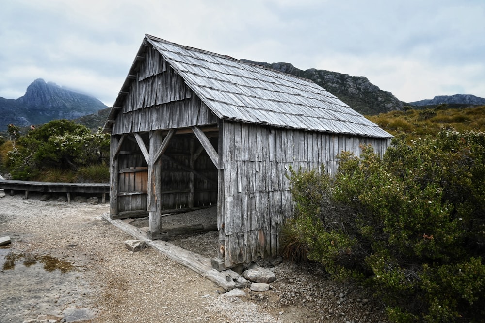 a small wooden building sitting on top of a dirt road