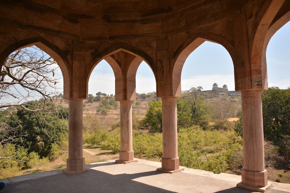 a large building with arches and pillars in the middle of a field