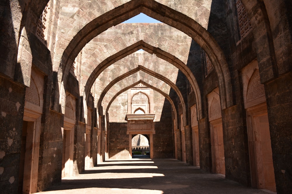 an archway in a stone building with a clock on the wall