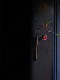 A minimalist modern floral arrangement in fuchsia and white tones displayed on a sleek gray background.