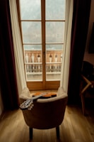 a guitar sitting on a chair in front of a window