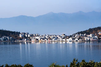 a town on a lake with mountains in the background