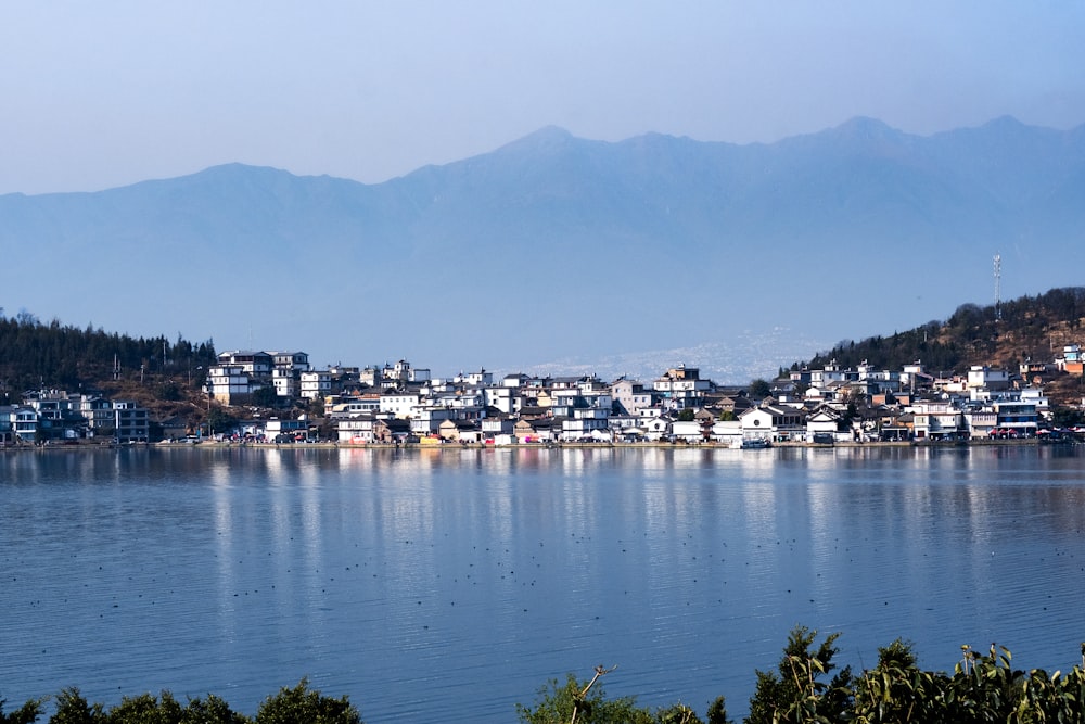 a town on a lake with mountains in the background