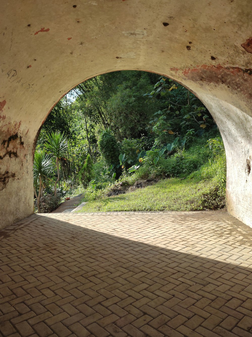 a view of a brick walkway through a tunnel