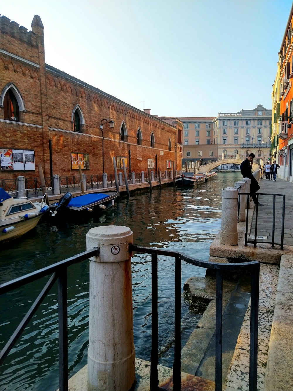 a man standing on a railing next to a body of water