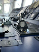 Control panel with illuminated buttons and screens inside a ship's bridge